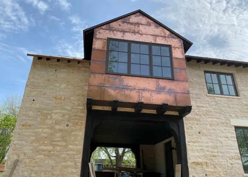 Copper metal panel facade on a stone building for Skylight Installation in Upper Milford